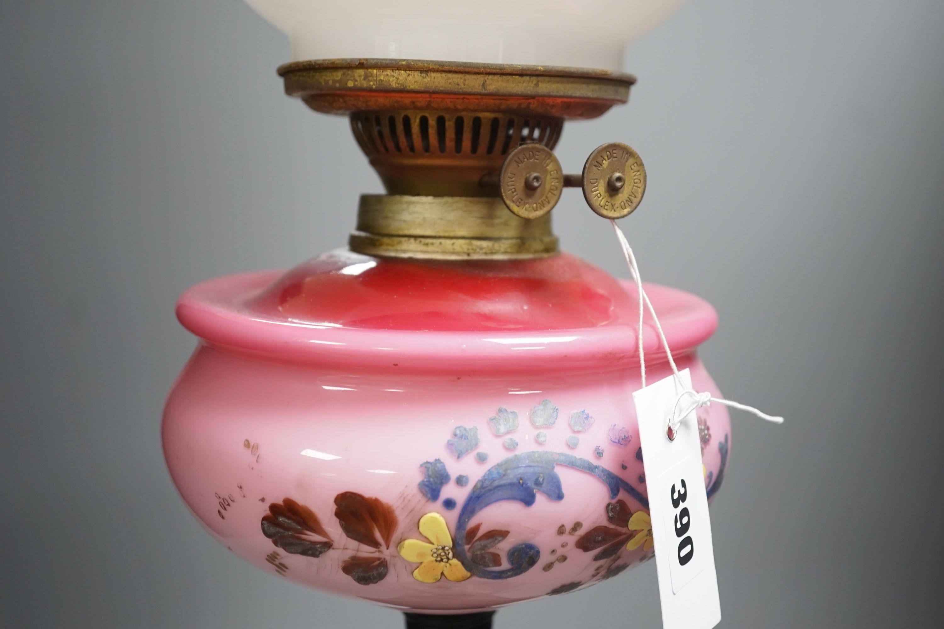 A Victorian cast iron and enamelled glass oil lamp